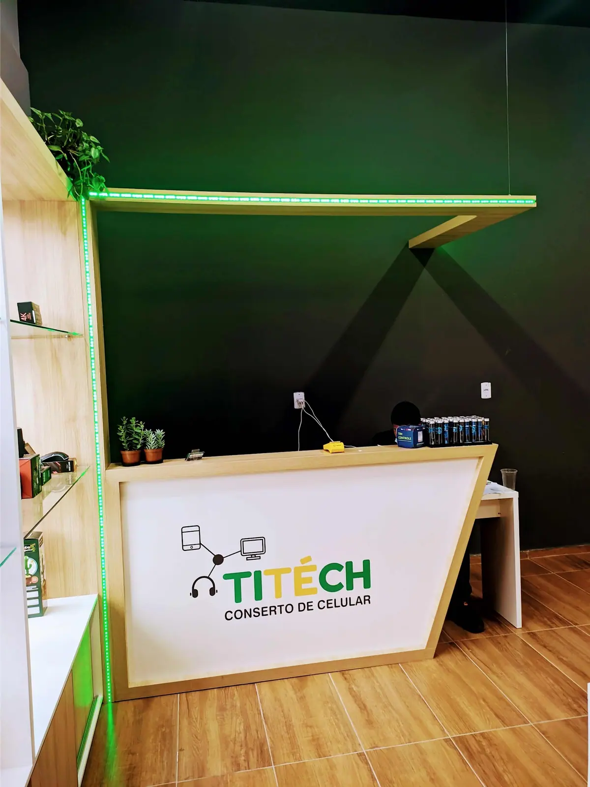 Balcão da TITÉCH com o logo da loja e luz de LED verde